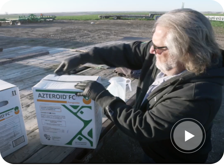 Farmer opening a box of Azteroid® FC 3-3 Fungicide